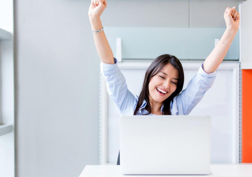 Woman celebrating at her computer